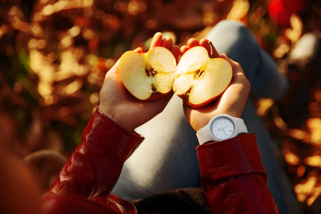 Credit: Pexels Jemand hält in jeder Hand eine Apfelhälfte.