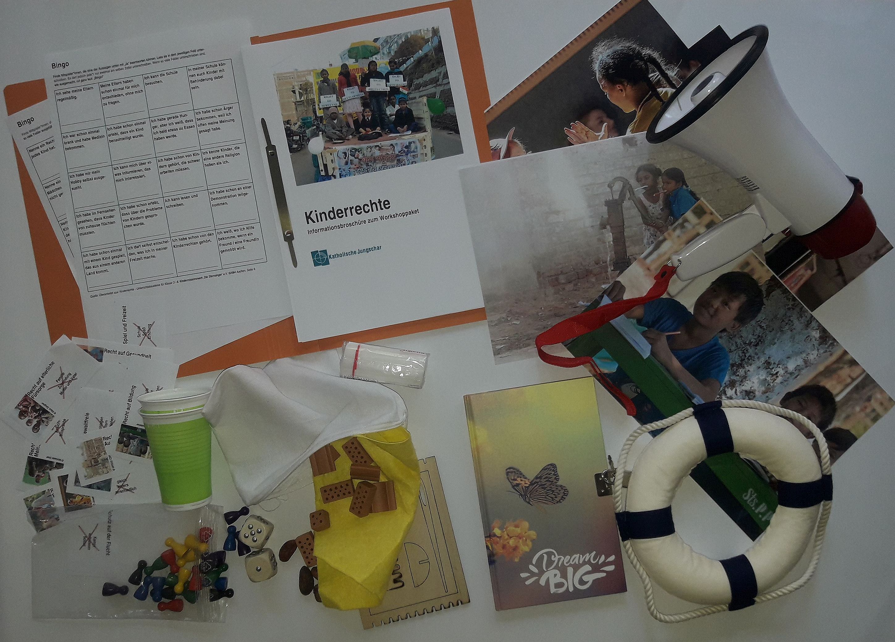 Credit: KJSÖ Der Inhalt des Kinderrechtepakets liegt auf: Dazu gehört zb. eine Infomappe, Bilder, ein Megaphon, ein Notizbuch, Spiele, ein Rettungsring,...