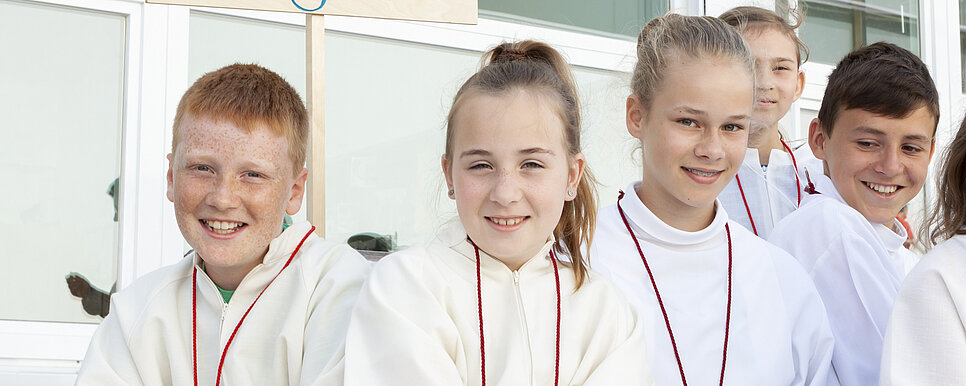 Fünf Ministrant/innen sitzen nebeneinander